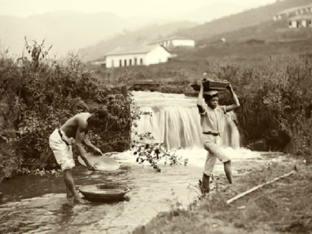 Sepia-toned historical photograph of two miners working on diamond exploration in a river in the Chapada Diamantina region. Sepia-toned historical photograph of two miners working on diamond exploration in a river in the Chapada Diamantina region.