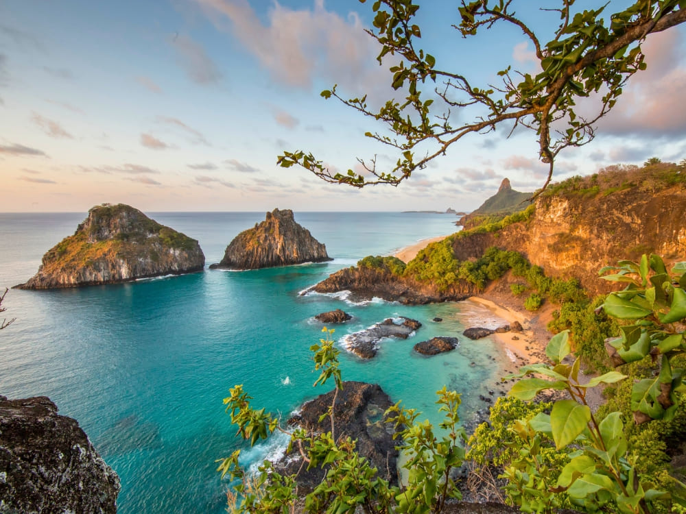 Coastal landscape with iconic pointed rock formations bathed by crystal clear, turquoise ocean waters.