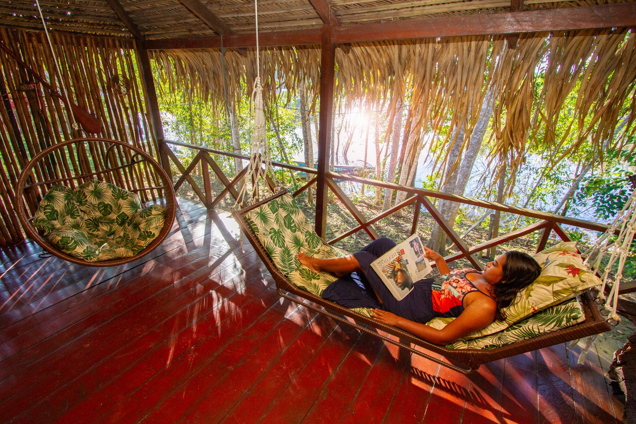 De beste plannen in het Amazonegebied beginnen soms met helemaal geen plannen. Een gast ligt ontspannen in een kussenzachte hangmat op de rieten veranda van het Amazon Turtle Lodge en leest een tijdschrift, terwijl zonlicht door de tropische bomen achter de houten balustrade schijnt