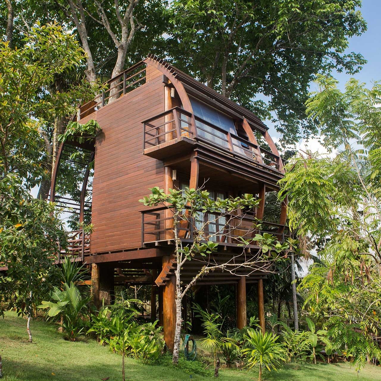 Op palen boven de jungle slapen: dit is precies zo goed als het klinkt. Een meerdere verdiepingen tellend houten boomhuis bij Mirante do Gavião rijst op palen op boven weelderige tropische tuinen, met omlopende balkons op elke verdieping en een gebogen gewelfdak omlijst door hoge regenwoudbomen