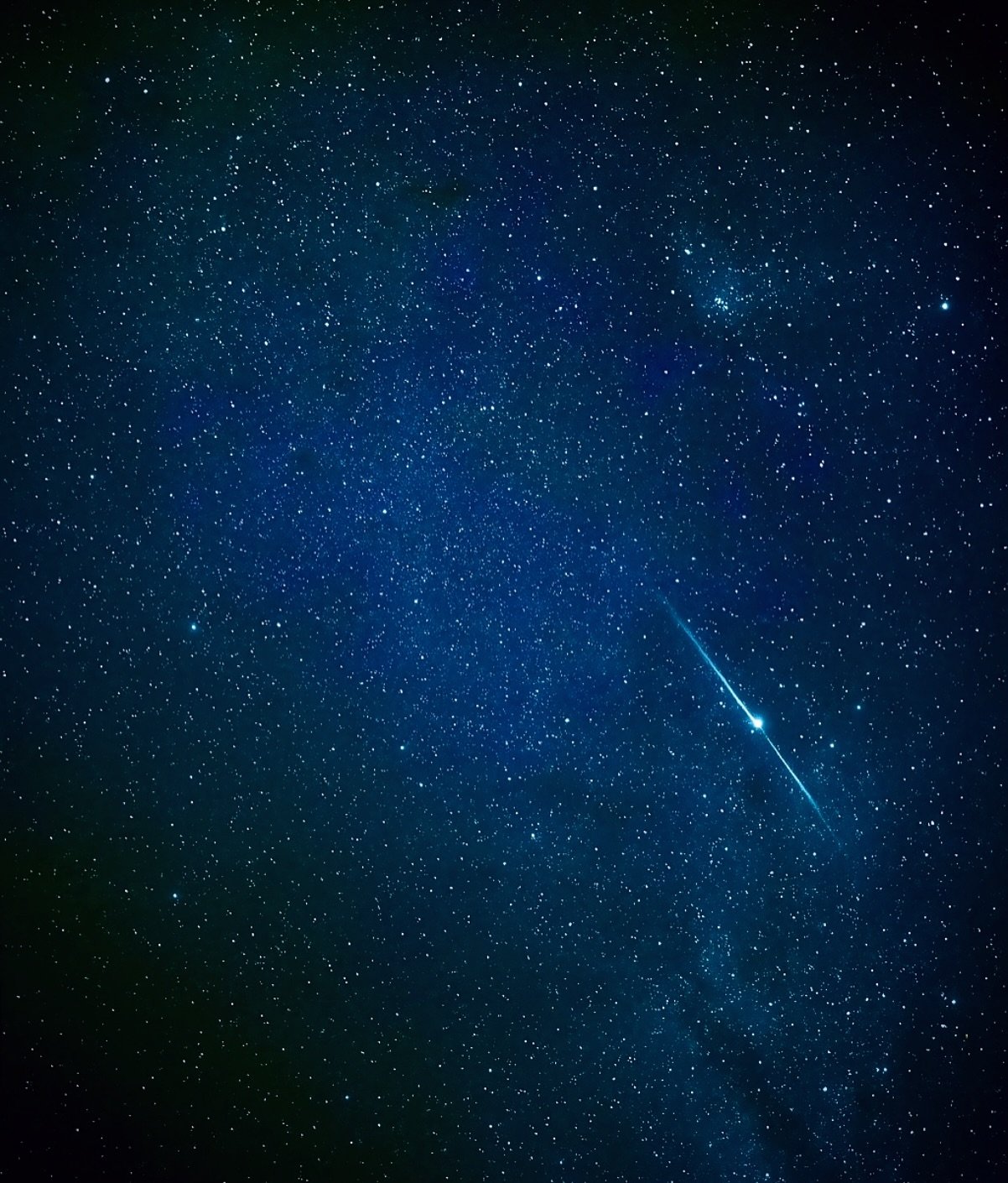 Um risco de luz no céu, rodeado de silêncio e estrelas. Um meteoro brilhante risca na diagonal um céu noturno azul profundo repleto de estrelas, com milhares de pontos de luz e o brilho suave da Via Láctea ao fundo