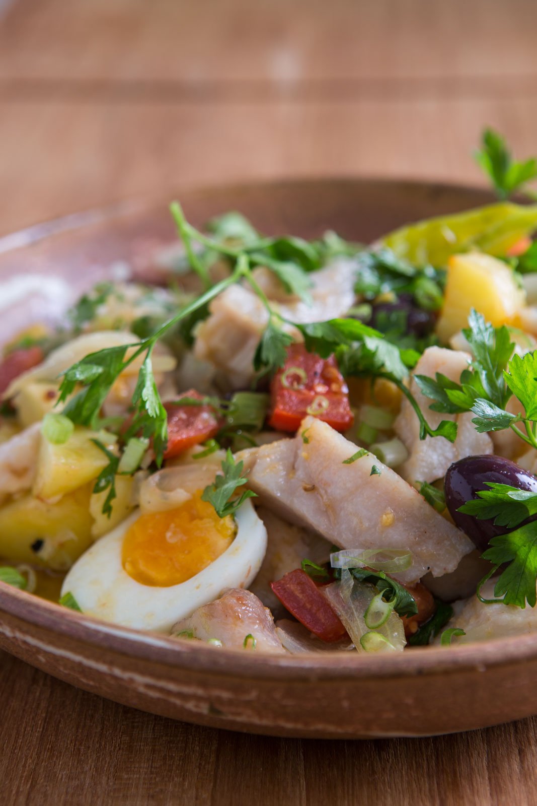 Fresh ingredients, bold flavours — dinner in the heart of the Amazon. Photo: Rjcastilho A rustic clay bowl filled with flaked white fish, boiled egg halves, diced yellow potato, black olives, chopped red sausage, spring onion and fresh parsley — a hearty lodge meal at Cristalino Jungle Lodge