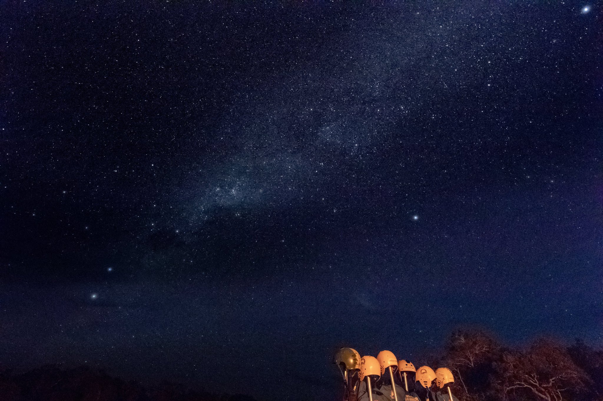 Countless stars, one unforgettable night under the cerrado sky. Photo: Alberto Andrich A row of telescopes glowing golden under a vast Milky Way sky during a Jalapão trekking night in the remote cerrado