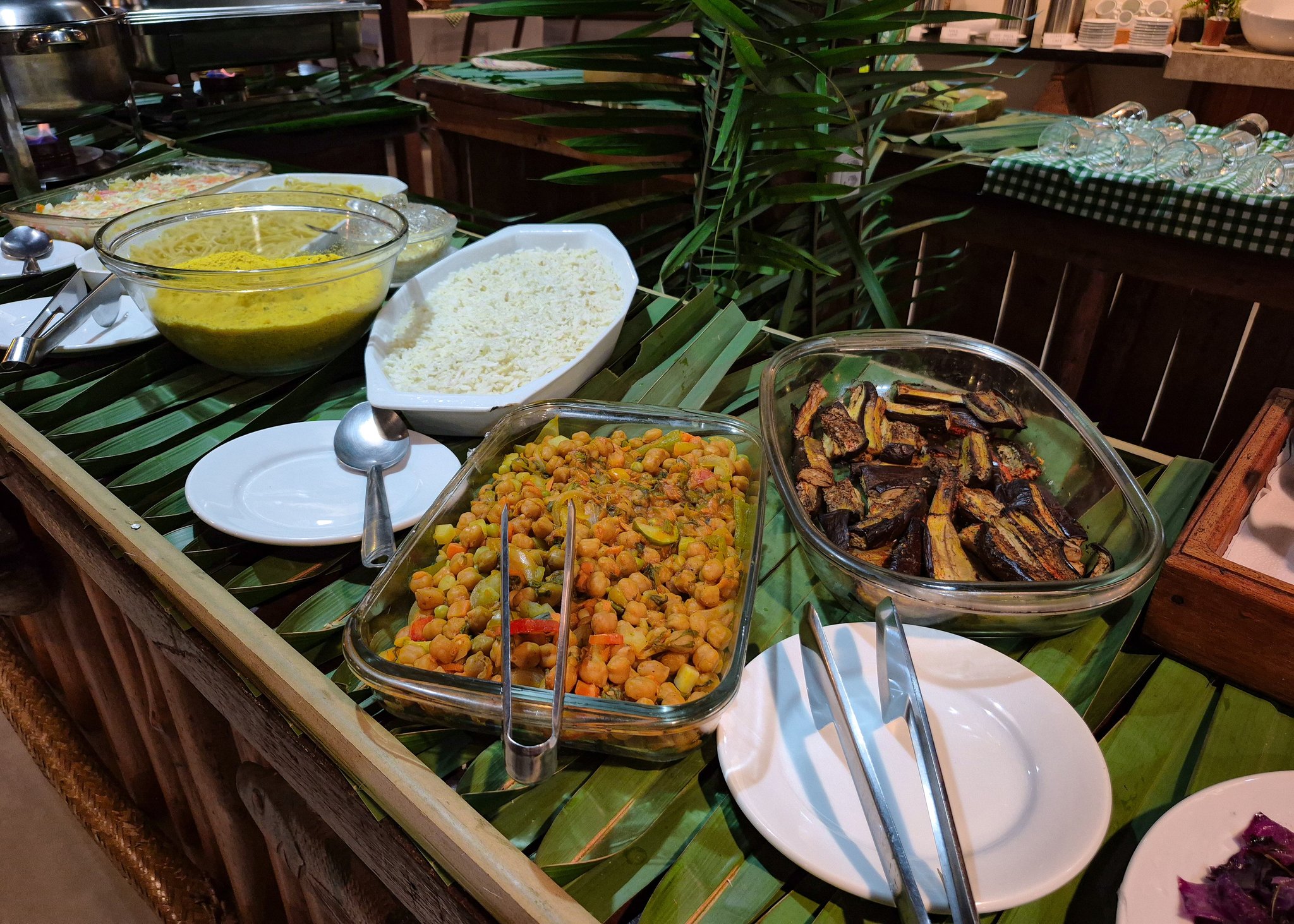 Vegetarian buffet of rice, chickpeas and grilled eggplant arranged on banana leaves at a jungle lodge