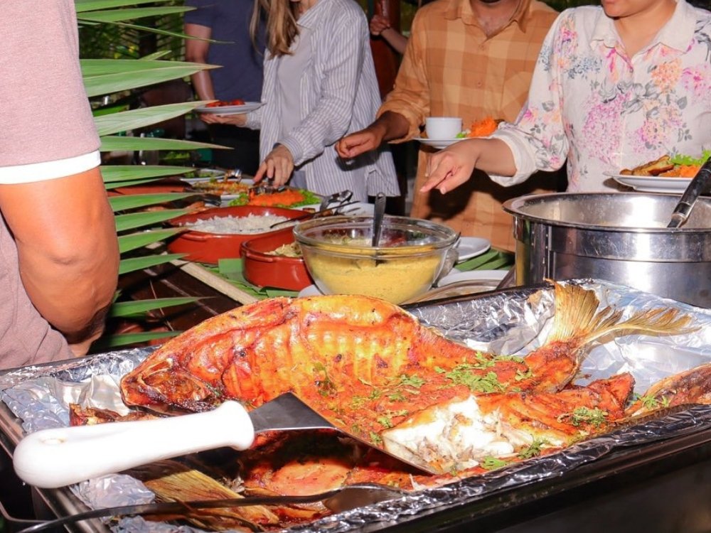 A whole grilled tambaqui takes centre stage at the lodge's regional buffet. Whole grilled Amazonian fish on a tray as guests serve themselves at the lodge buffet