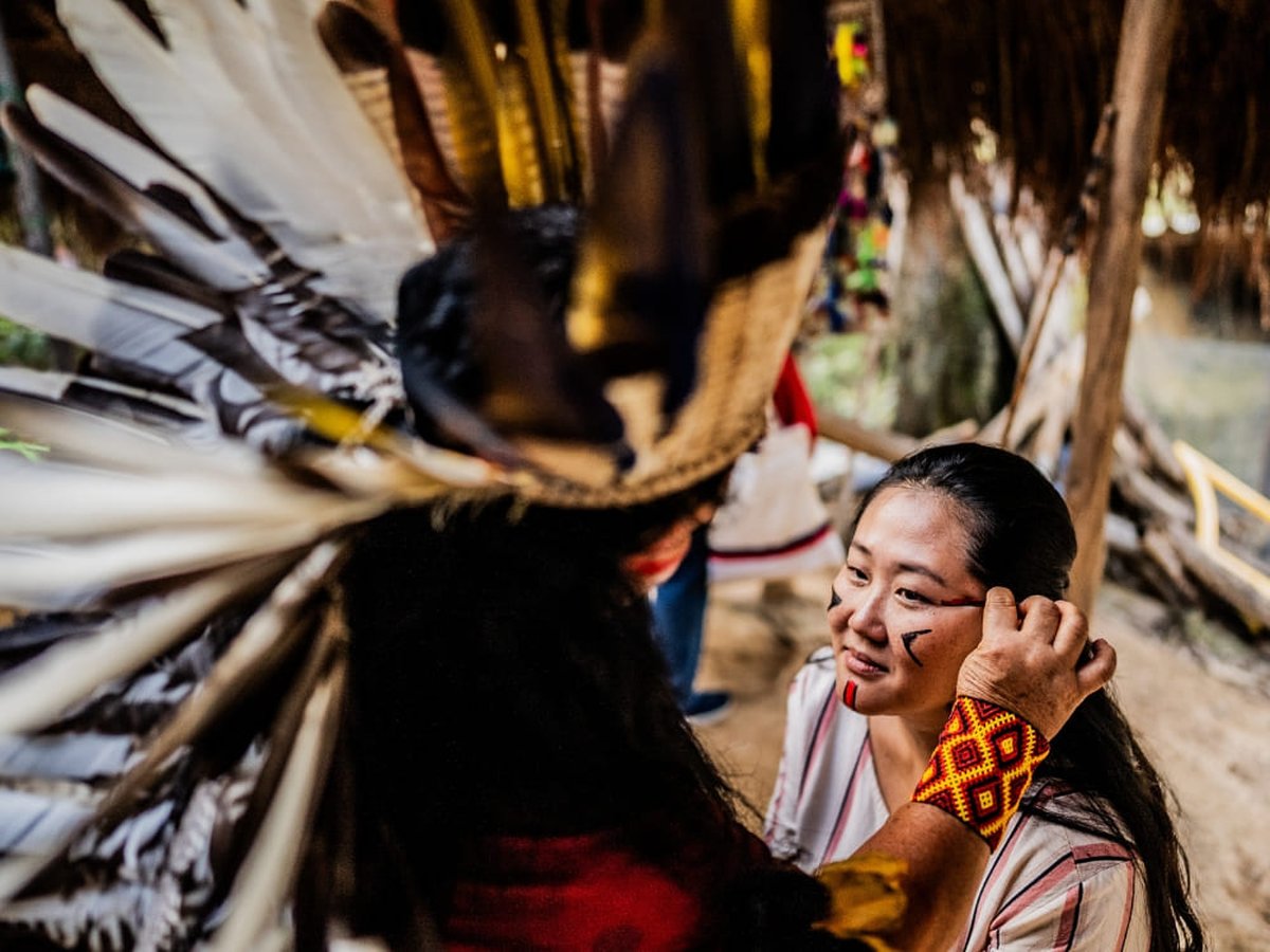 Traveler receiving traditional Indigenous face paint during a community visit in the Amazon