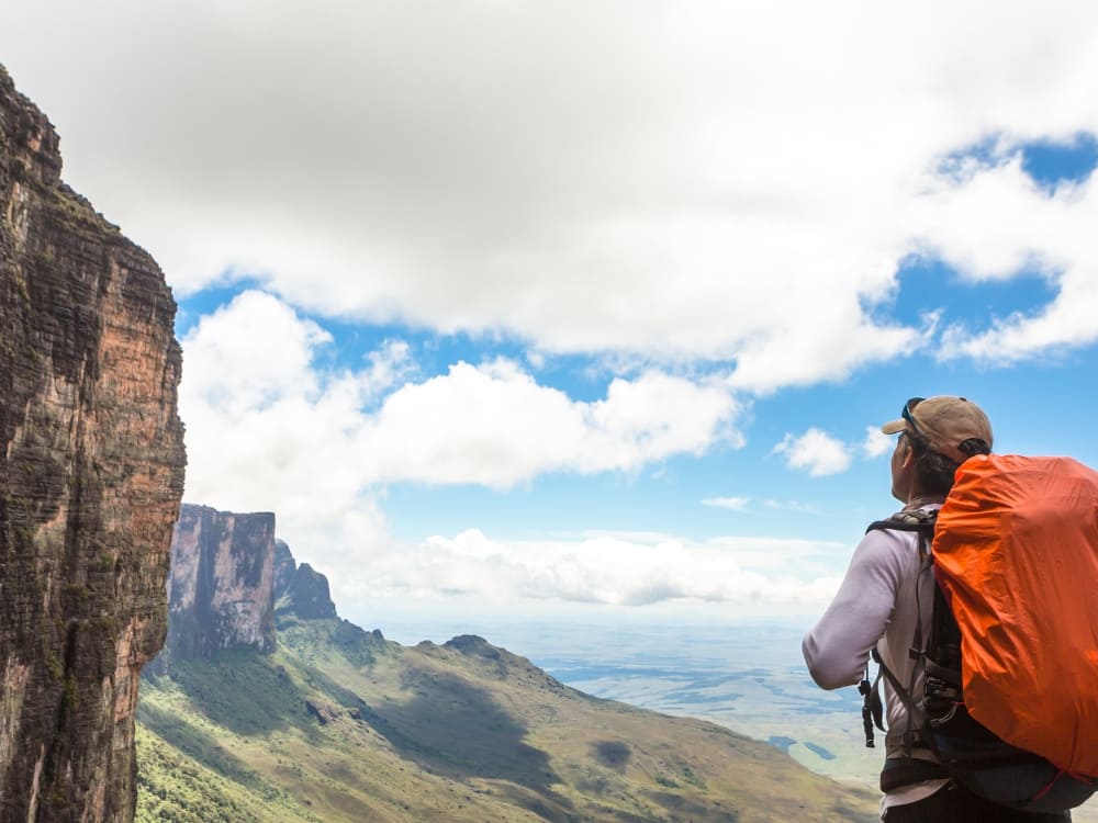 A hiker at a viewpoint over the tepui cliffs of Mount Roraima
