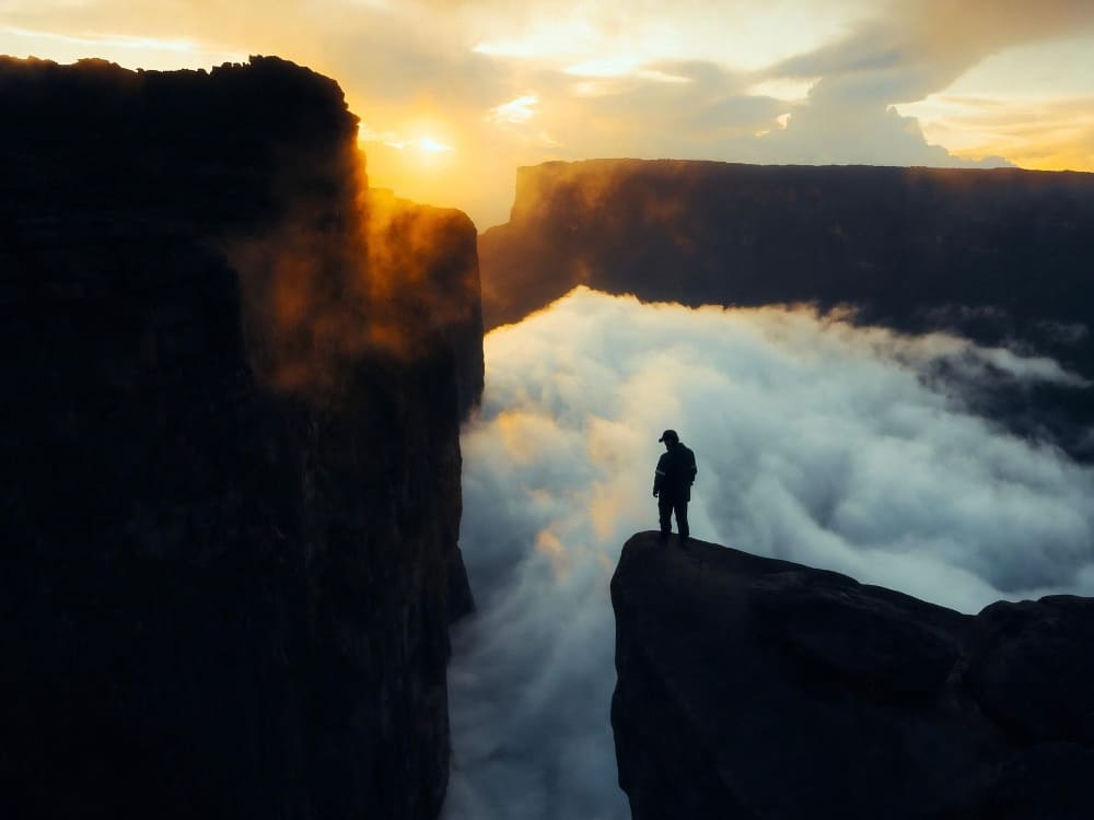 Sunset over the cliff edge of Mount Roraima's summit, above a sea of clouds