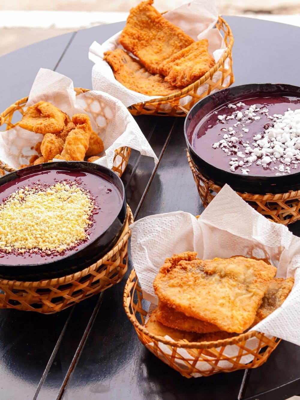 Schalen mit dickem, ungesüßtem Açaí und Maniokmehl, dazu Körbe mit frittiertem Fisch in Pará