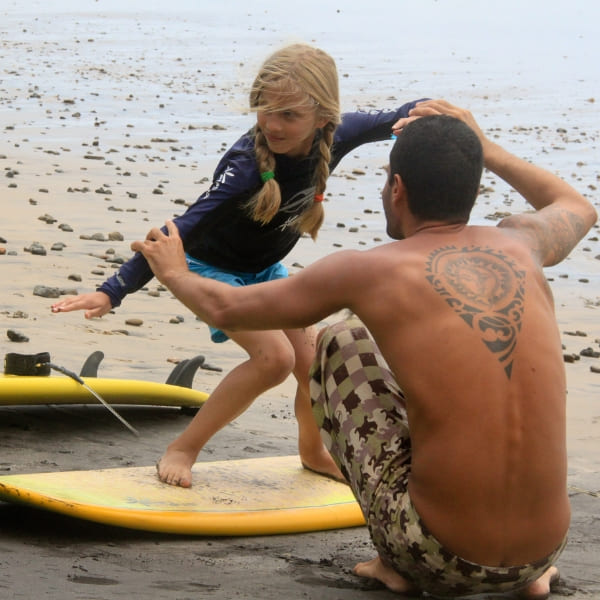 Ein Kind nimmt am Strand von Itacaré, Bahia, eine Surfstunde, Brasilien.