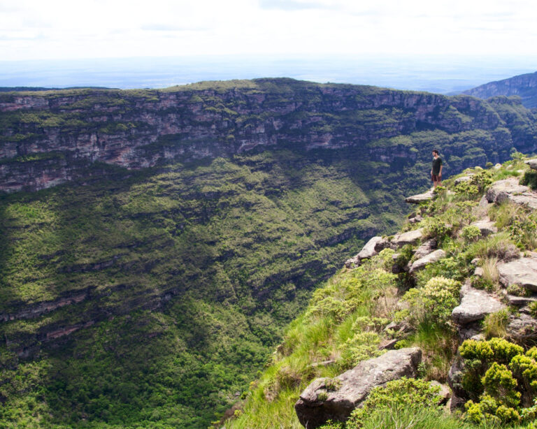 Un randonneur au bord d'une falaise dominant une vallée verdoyante dans la Chapada Diamantina, Brésil. Un randonneur au bord d'une falaise dominant une vallée verdoyante dans la Chapada Diamantina, Brésil.
