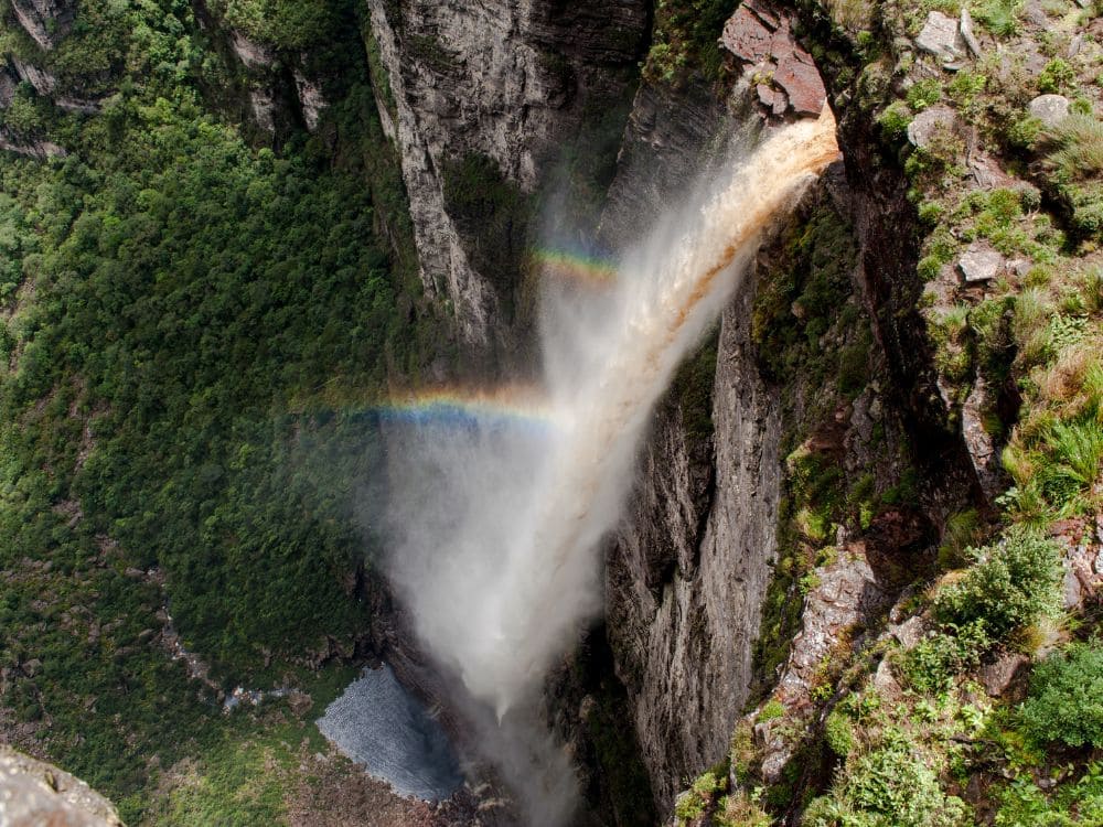 Luftaufnahme der Cachoeira da Fumaça, die mit einem Regenbogen in der Gischt ins Tal stürzt, Chapada Diamantina, Brasilien.