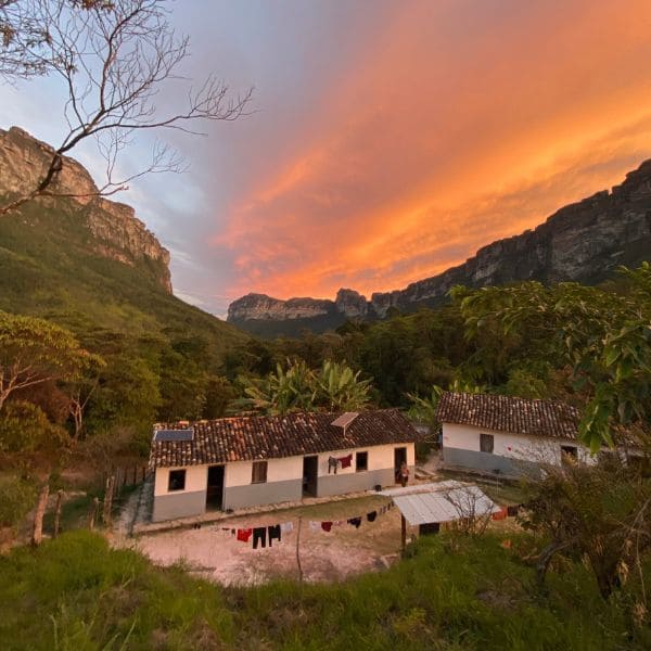 Häuser der Dorfbewohner im Vale do Pati unter einem feurigen Abendhimmel in der Chapada Diamantina, Brasilien.