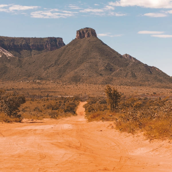 Eine rote Sandpiste führt durch den Cerrado auf einen Tafelberg im Jalapão zu, Tocantins, Brasilien.