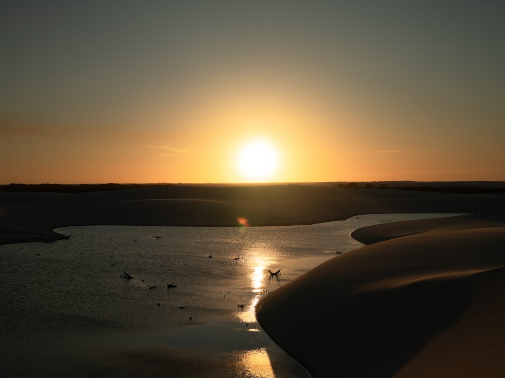 Coucher de soleil sur une lagune d’eau de pluie entre les dunes blanches des Lençóis Maranhenses