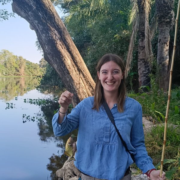 La hija de Sally sostiene un pez pescado en el río