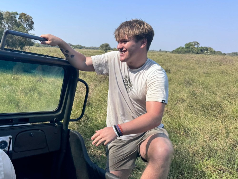 El hijo de Sally sube a la camioneta de safari, con tatuajes temporales de fruta en el brazo