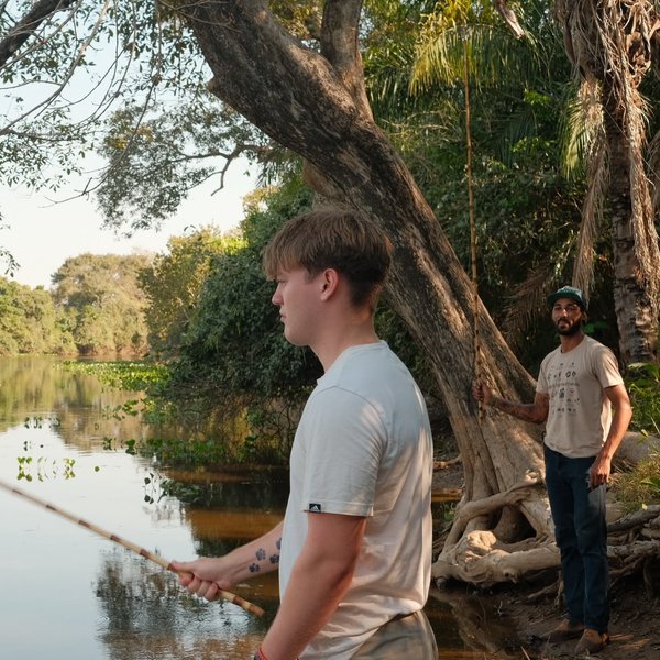 El hijo de Sally pescando en el río con el guía local