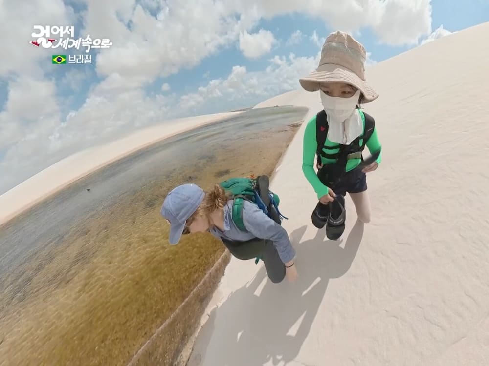 Jihee Yeon and a fellow trekker at the edge of a lagoon among the dunes of Lençóis Maranhenses