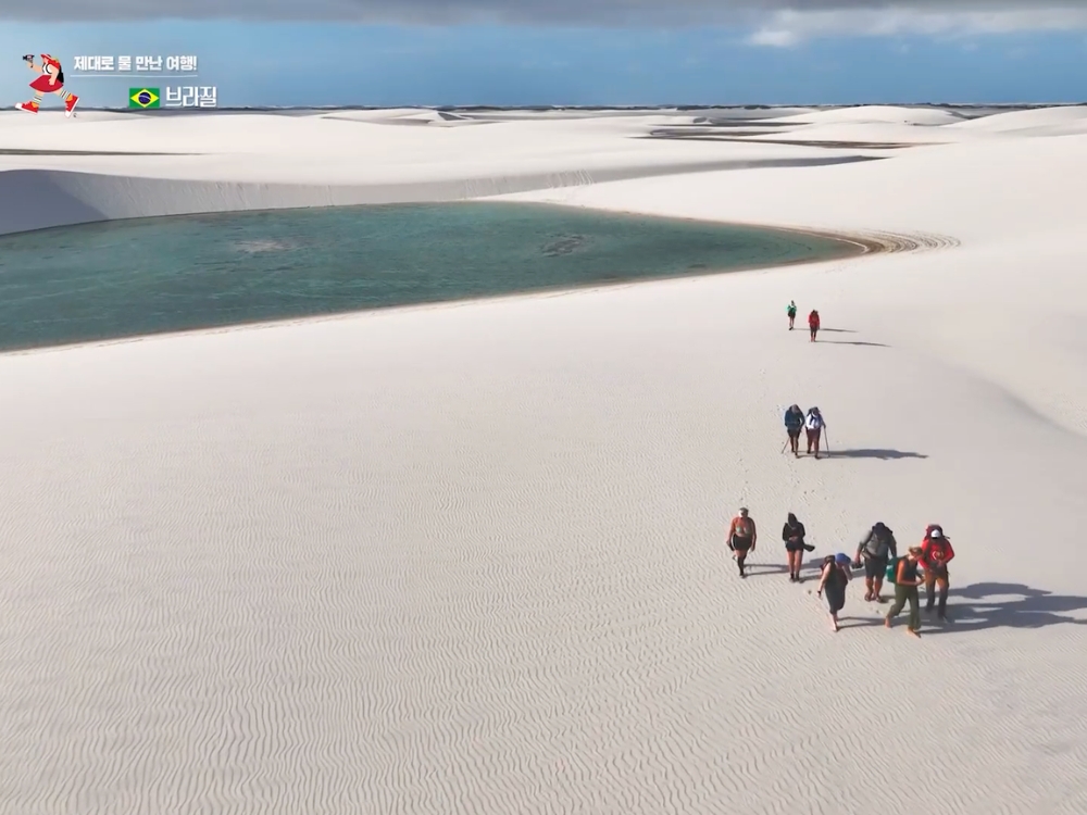 Mano que sostiene un nenúfar blanco y pequeñas flores silvestres recogidas a orillas de una laguna de los Lençóis Maranhenses