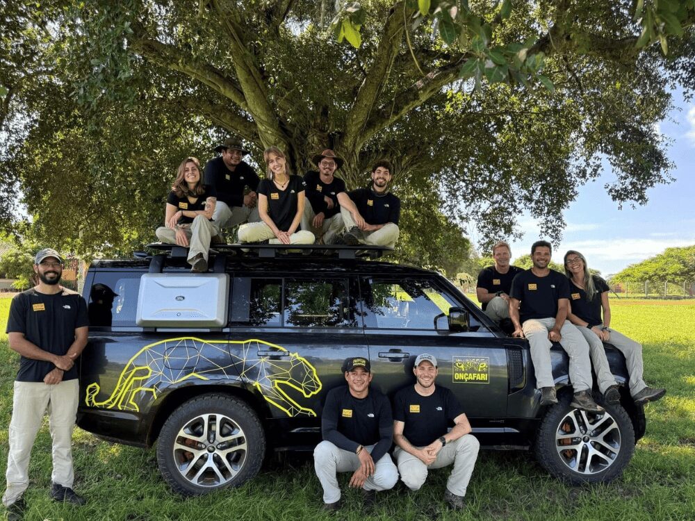 L’équipe d’Onçafari réunie autour d’un Land Rover Defender orné d’un jaguar jaune