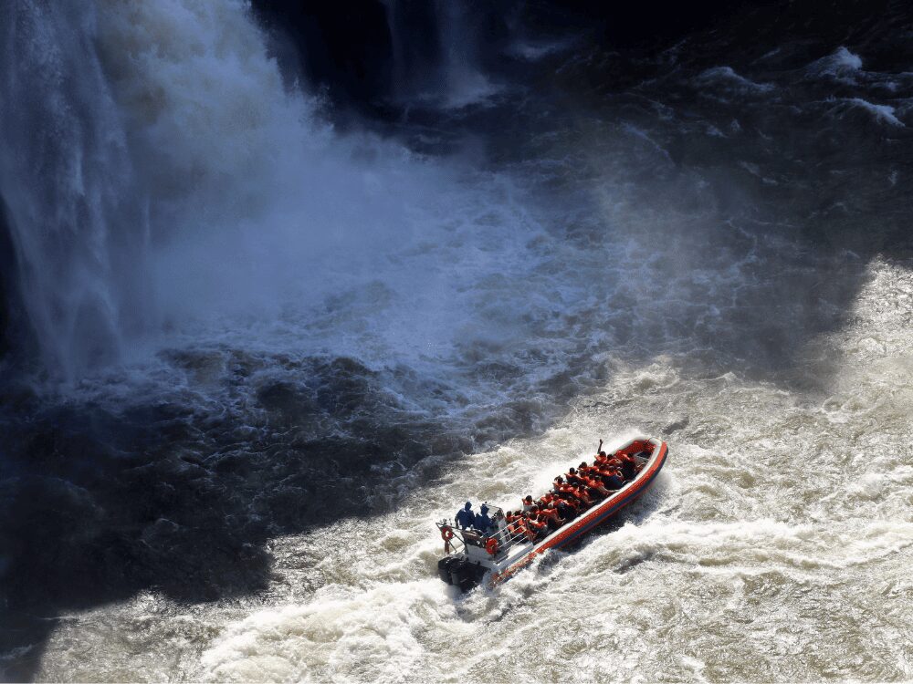 Excursion en bateau avec des passagers en gilet de sauvetage filant vers les embruns des chutes d'Iguazu