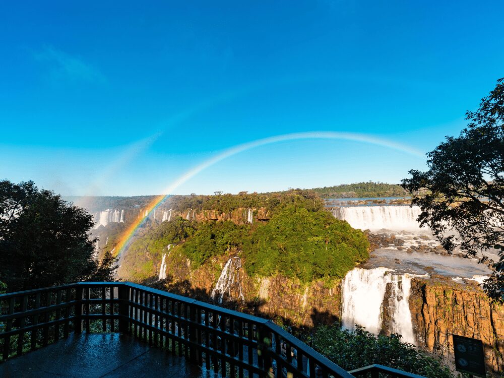 Arc-en-ciel au-dessus des chutes d'Iguazu vu depuis un belvédère par temps clair