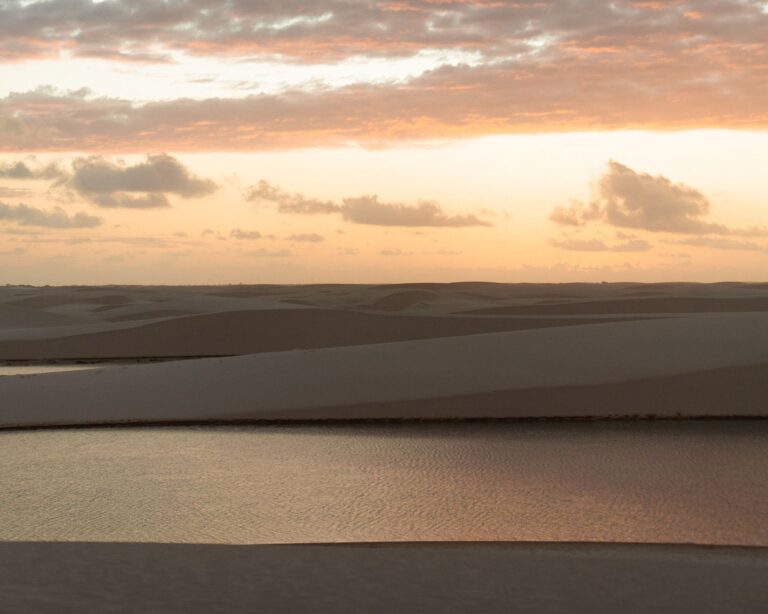 Pink sunset sky over the white sand dunes and a rainwater lagoon in Lençóis Maranhenses Pink sunset sky over the white sand dunes and a rainwater lagoon in Lençóis Maranhenses