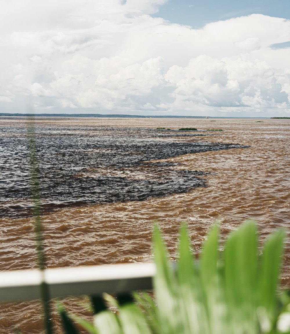 La Rencontre des eaux vue d’un bateau à Manaus, l’eau sombre du rio Negro tourbillonnant dans le Solimões brun